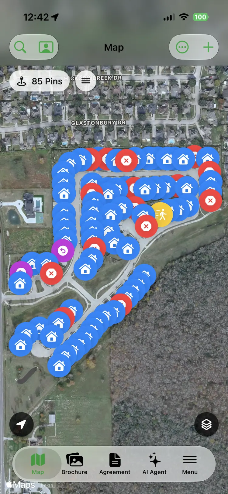 A satellite knocking map of a neighborhood covered in color-coded pins — blue for houses worked, red for not interested, yellow for not home — with a counter reading 85 pins.